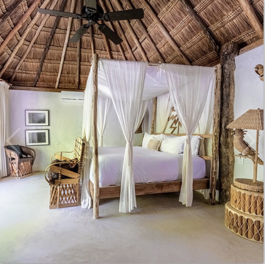 A bedroom with a bed and a ceiling fan.